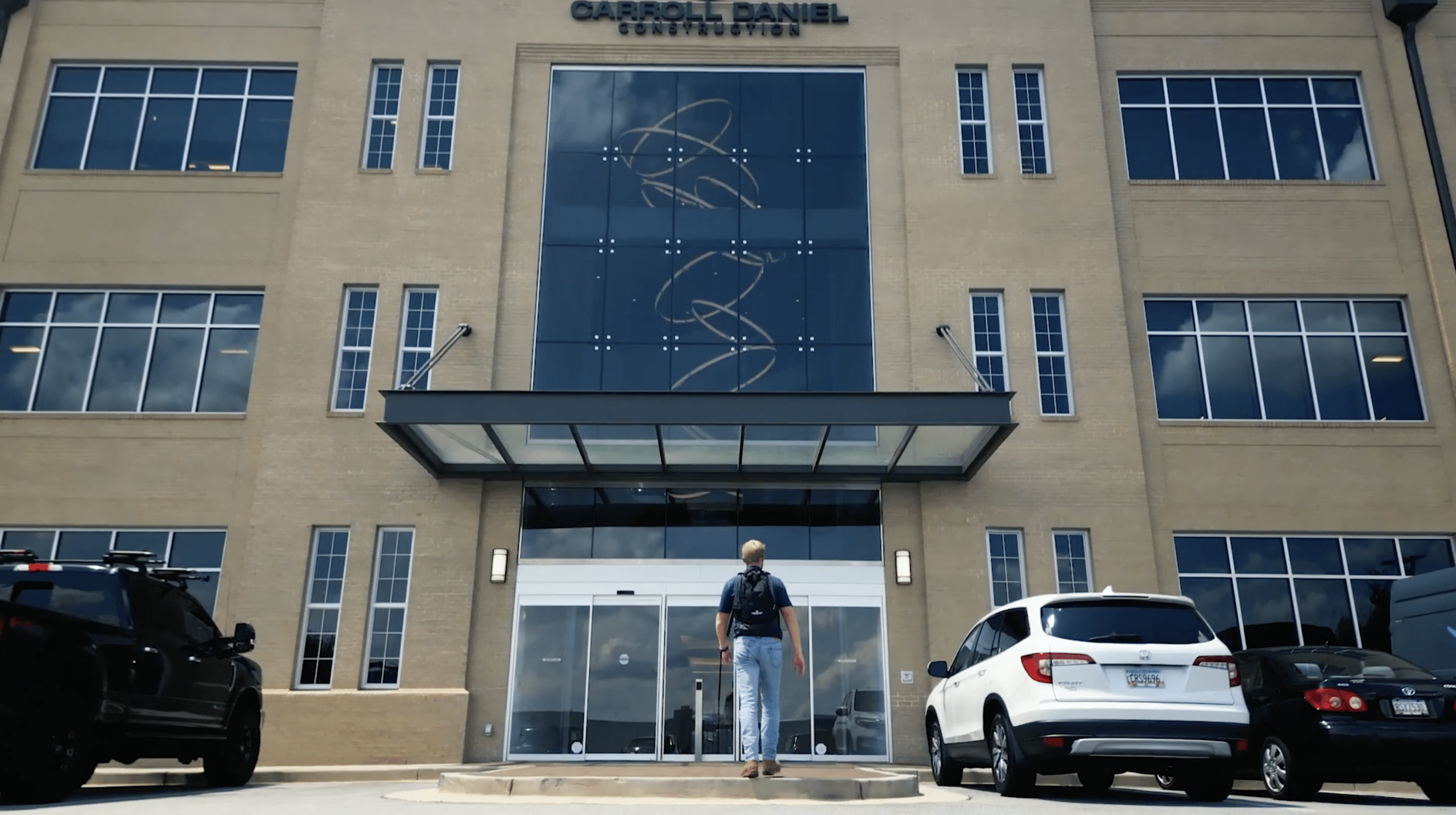 picture of an intern walking into the front doors of carroll daniel construction's gainesville, georgia office building